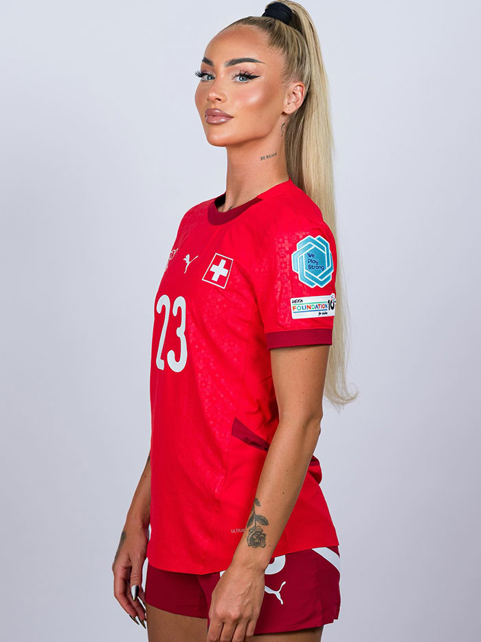 World's prettiest footballer in red team jersey posing confidently, showcasing stunning transformation and athletic style.