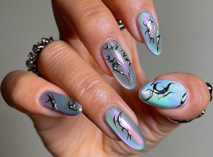 Close-up of pearlescent almond nails with black abstract designs, showcasing trending almond nails styles for 2025.