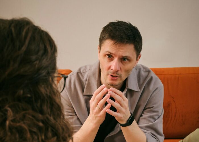 Man explaining with hand gestures in a serious conversation about what makes a man instantly unattractive to women