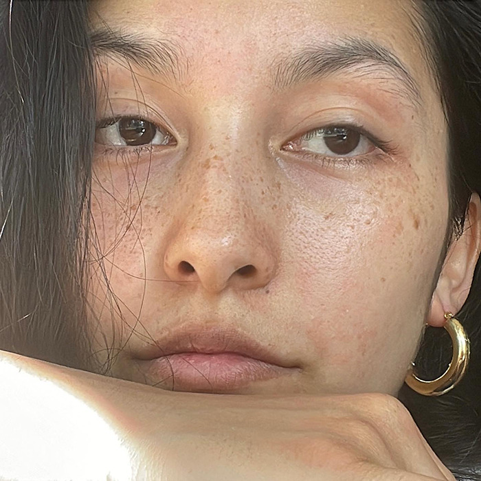 Shiloh Jolie-Pitt close-up with natural makeup and gold hoop earring, sparking romance rumors at age 19.