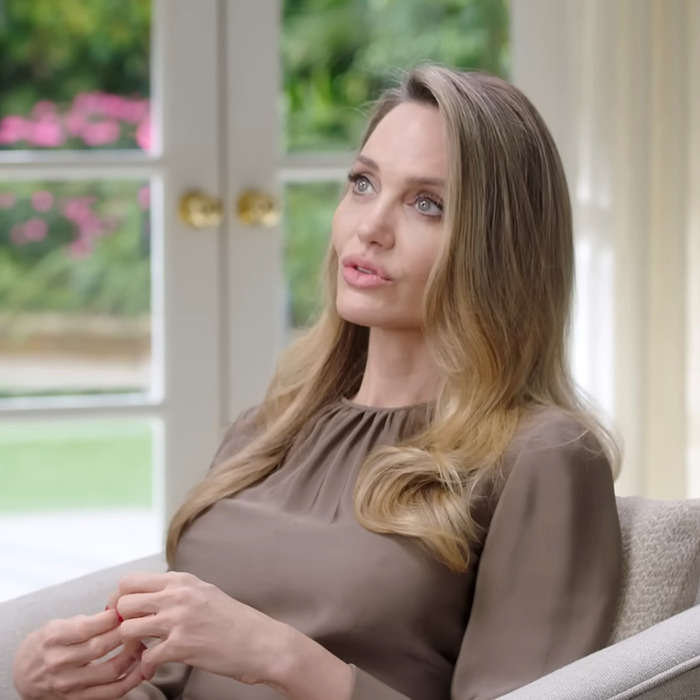 Angelina Jolie speaking indoors with long blonde hair, fueling Shiloh Jolie-Pitt romance rumors in a candid interview.