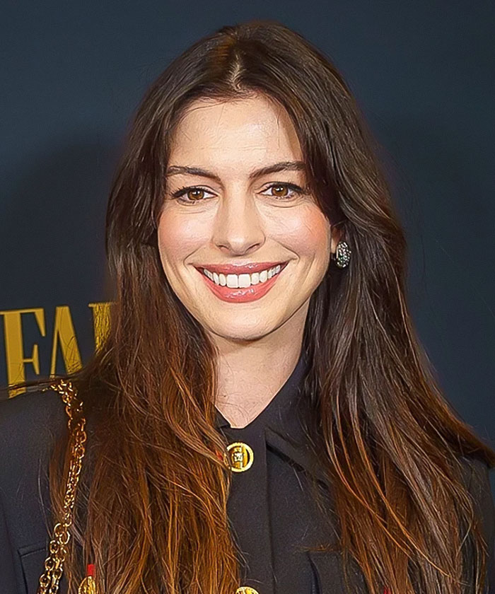 Anne Hathaway smiling at an event, wearing black with gold details, spotlight on her Vogue cover photoshoot backlash. Anne Hathaway smiling at an event, wearing black with gold details, spotlight on her Vogue cover photoshoot backlash.
