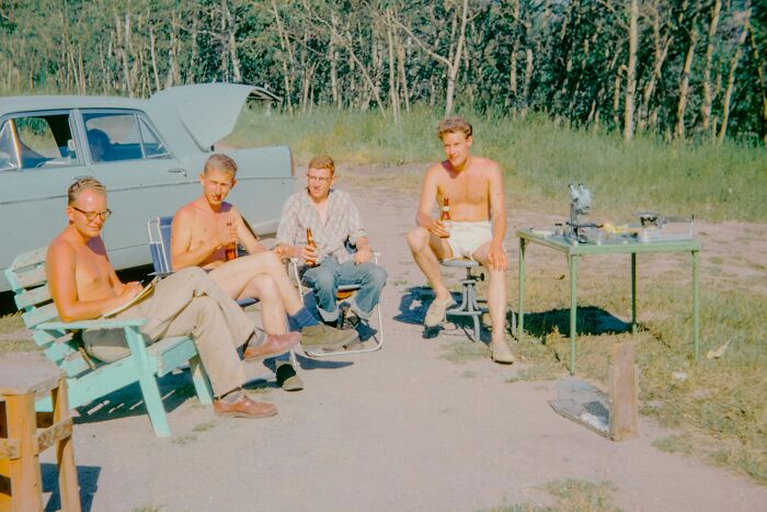 Group of young men casually sitting outdoors near a car, depicting relaxed vibes and subtle red flag behaviors romanticized by people. - 26