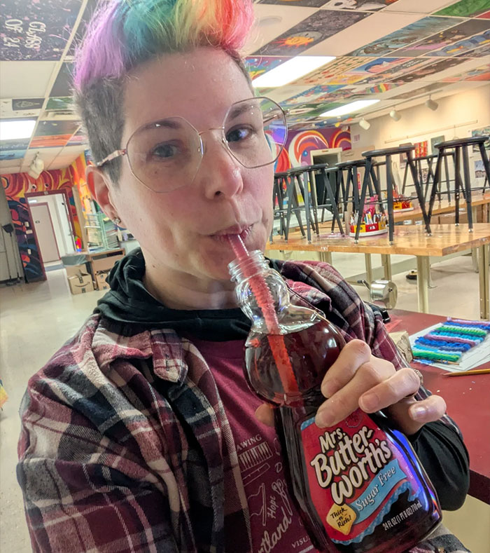 Person with colorful hair sipping from a syrup bottle using a straw, showcasing creative sippers choosing alternatives to cups.