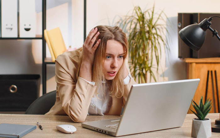 Woman looking stressed at laptop, contemplating asking husband to turn down dream job and career opportunity. - 1