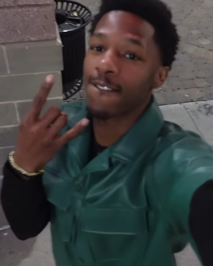 Young viral sprinter wearing green jacket posing outdoors after gaining modeling offers following race incident. Young viral sprinter wearing green jacket posing outdoors after gaining modeling offers following race incident.