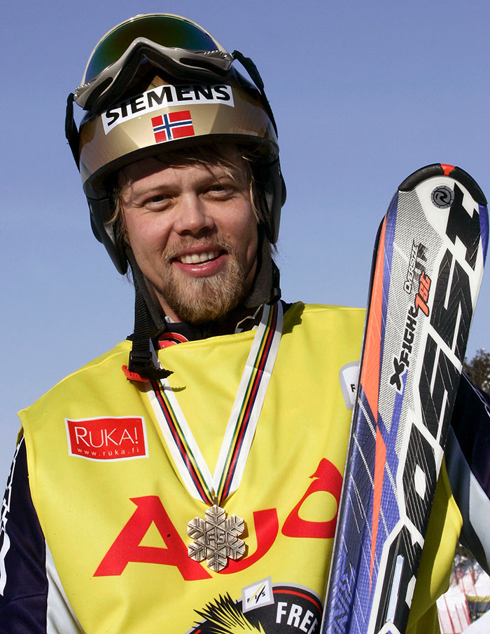 Olympic medalist skier smiling with helmet and ski gear after winning a competition outdoors on a clear day - 13