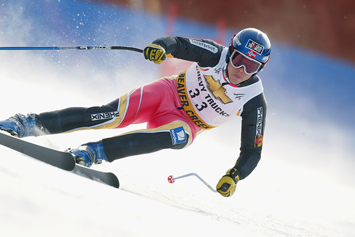 Olympic medalist skier racing downhill in full gear during a competitive skiing event on a snowy slope. - 9
