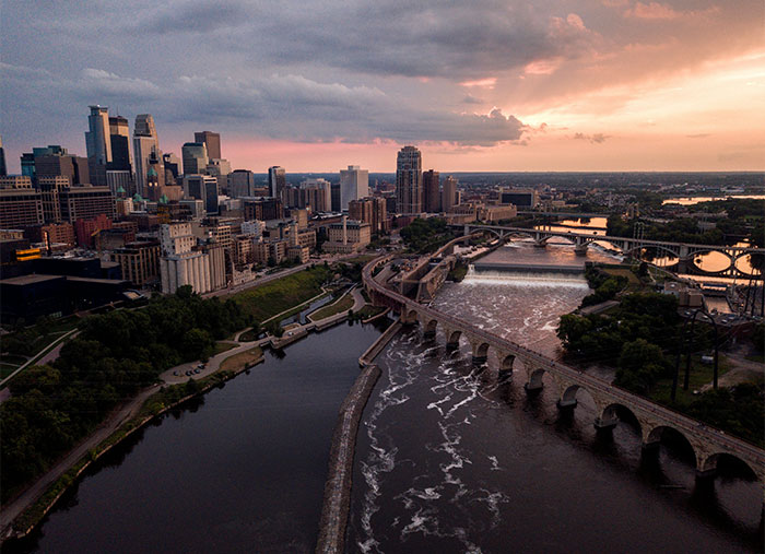 Aerial view of a US city skyline at sunset with bridges over a river representing average IQ in the USA 2025 state leaders.