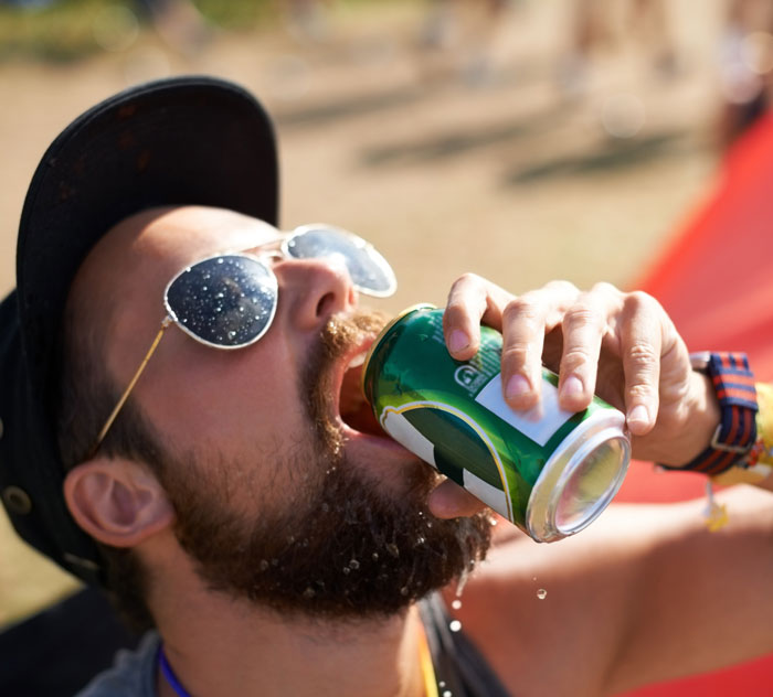 Man wearing sunglasses and cap drinking canned beverage outdoors amid extreme heat warnings in multiple states - 2