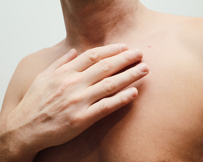 Close-up of a man’s hand on bare shoulder, illustrating skin-to-skin contact related to baby girl micropenis keyword. - 8