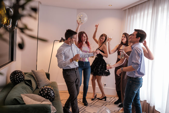 Man’s baby shower with friends showing celebration and drinks in a modern living room setting. - 1