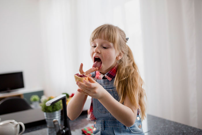 Young girl enjoying a sweet treat with a sugar rush, embodying a mini metalhead vibe during babysitting time. Young girl enjoying a sweet treat with a sugar rush, embodying a mini metalhead vibe during babysitting time.