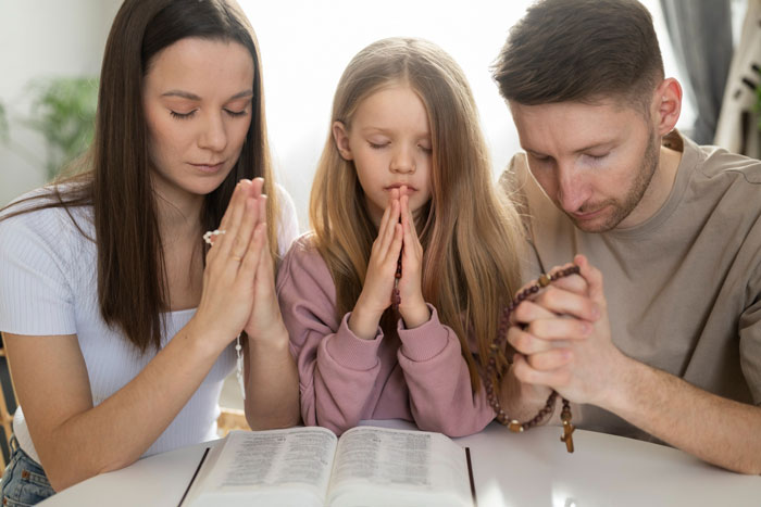 Family praying together with a study Bible while babysitting nephews, focusing on faith and prayer time. Family praying together with a study Bible while babysitting nephews, focusing on faith and prayer time.