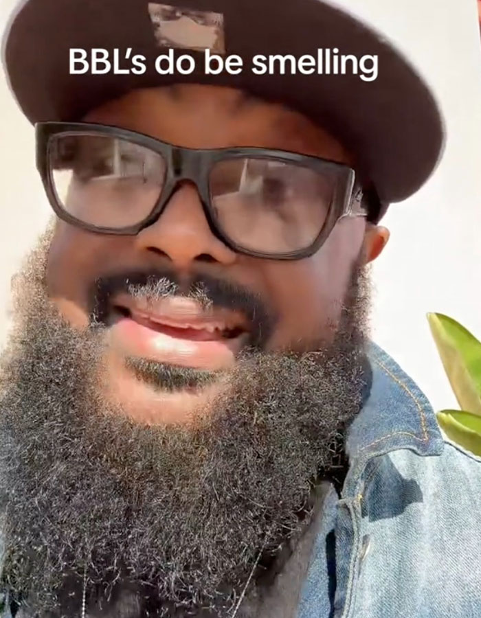 Man with glasses and a thick beard wearing a cap, discussing the BBL smell issue and patient struggles with hygiene.