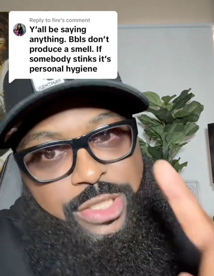 Man with glasses and hat responding to comment about BBL smell and personal hygiene in a casual indoor setting.