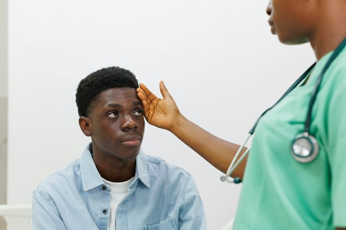 Doctor examining a young patient showing signs of needing less medication and more common sense during the visit.