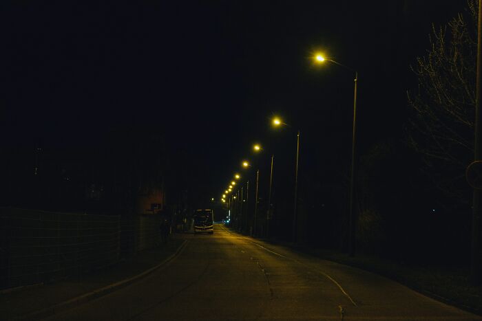 Dark empty street at night lit by streetlights, illustrating the experience of night shift workers and overnight work benefits. - 22