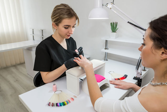 Woman getting nails done in a studio, highlighting a scene involving a wannabe influencer and studio party conflict.