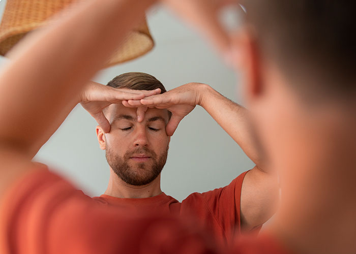 Man practicing life cheat codes by calming his mind with a focused meditation technique in front of a mirror. - 1