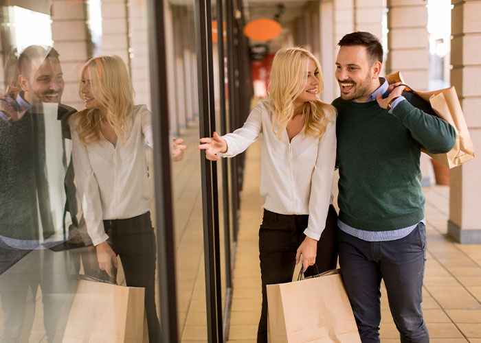 Couple shopping happily together carrying bags, illustrating life cheat codes for easier everyday living. - 12