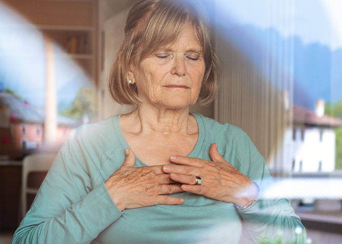Elderly woman practicing mindful breathing as a life cheat code for relaxation and stress relief at home. - 9