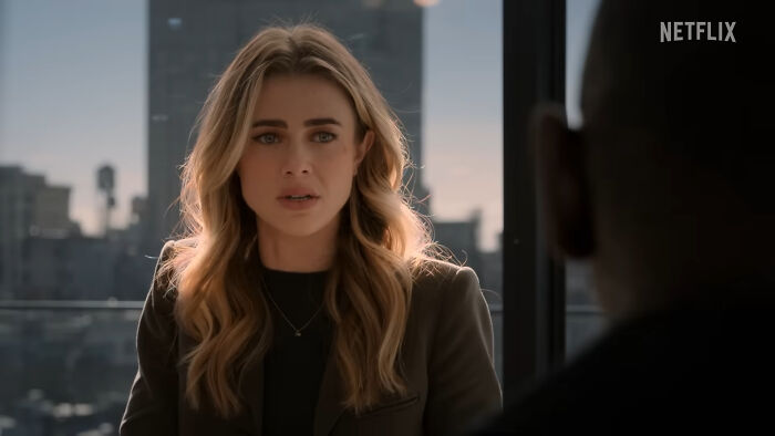 Woman with blonde hair in a meeting, representing viewers of the best Netflix shows that keep them coming back for more. - 25