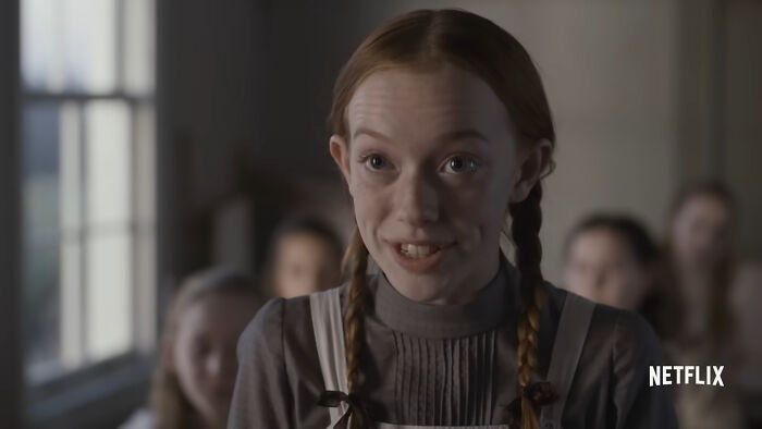 Young girl with braided hair smiling in a classroom scene from one of the best Netflix shows keeping viewers coming back. - 20