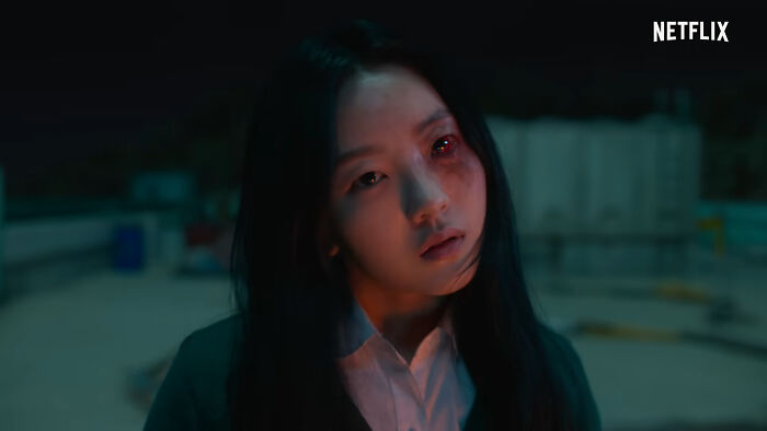 Young woman with glowing red eyes on rooftop scene from one of the best Netflix shows that keep viewers coming back. - 10