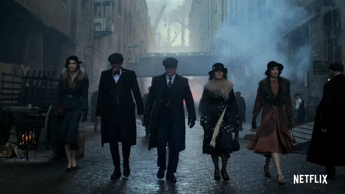 Group of five characters walking in a foggy, historic alleyway from one of the best Netflix shows praised by netizens. - 4