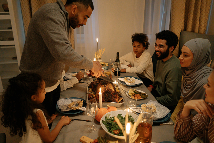 Family dinner scene with a man serving food, highlighting brother and girlfriend relationship tension and insecurity issues.