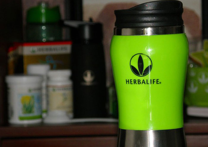 Green Herbalife shaker bottle on a kitchen counter with supplements, highlighting home red flags on a first date.