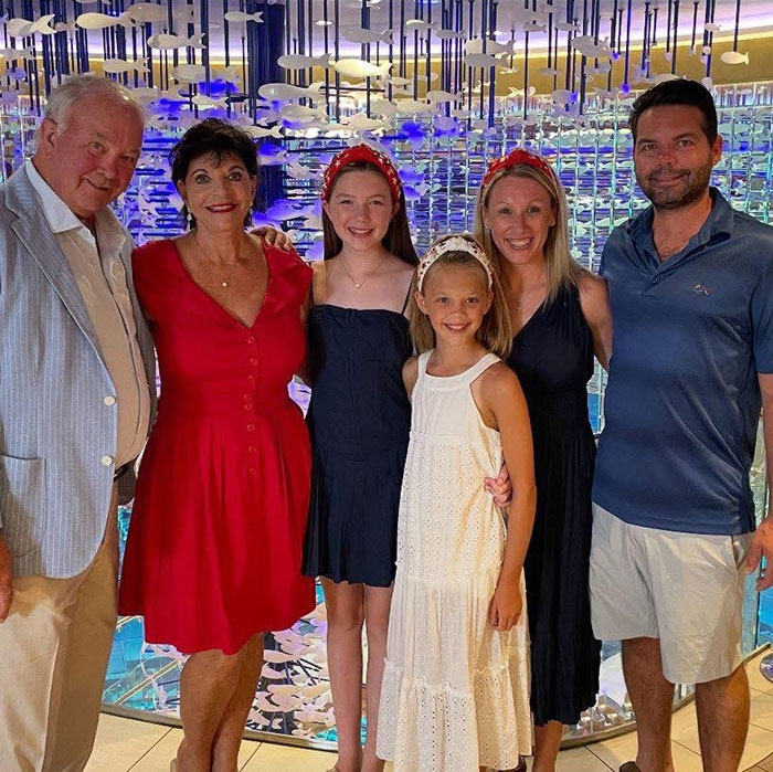 Family standing together indoors, remembering sisters who lost their lives in Texas floods with hands locked together.