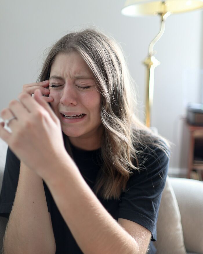 Young woman crying distressed after hearing disturbing things people overheard in a conversation indoors