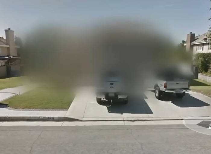 Blurred houses on Google Maps with two pickup trucks parked in the driveway, illustrating the risk of blurring homes online.