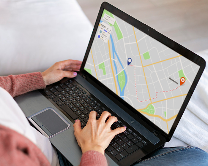 Person using a laptop showing a digital map, illustrating the reason people are blurring their houses on Google Maps.