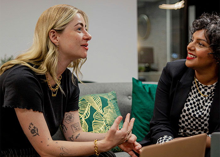 Two women discussing data and workplace challenges in an office setting, highlighting issues with fudging data.