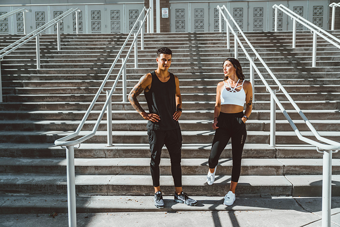 Two young adults in athletic wear standing on outdoor stairs, representing themes of friendship and weight loss before wedding. Two young adults in athletic wear standing on outdoor stairs, representing themes of friendship and weight loss before wedding.
