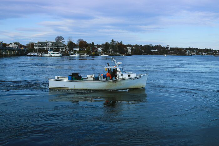 Fishing boat on calm water near shore with houses in the background, illustrating moments when a gut feeling saved lives.