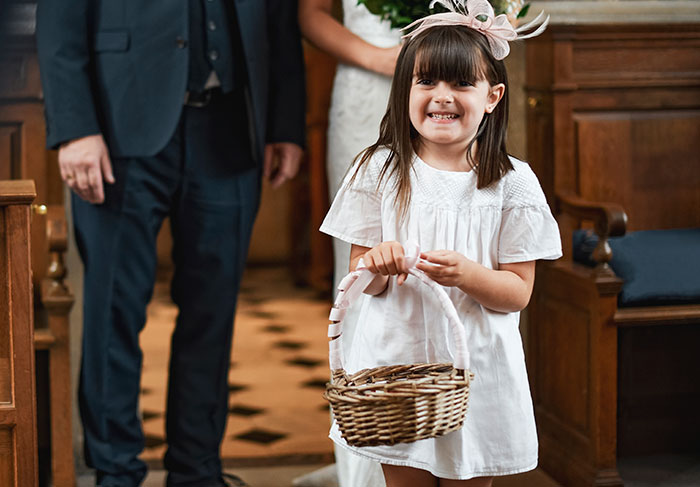 Young girl in a white dress holding a basket at a wedding, capturing woman stunned by acquaintance’s unusual request. - 1