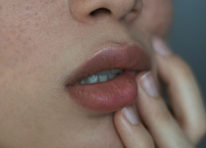 Close-up of a person’s lips and fingers, highlighting raw emotion and honesty in personal expression. - 2