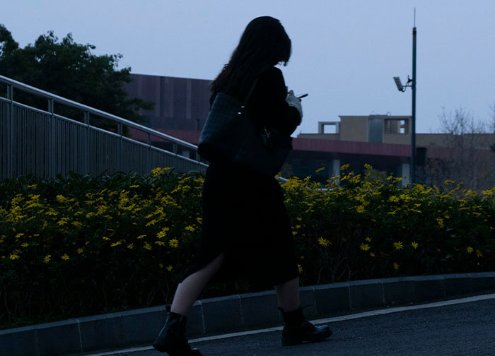 Silhouetted woman walking alone near yellow flowers at dusk, capturing the theme of men brutally honest and sharing feelings. - 14