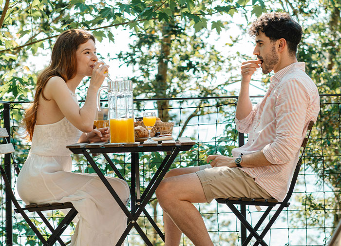 A man and woman having a candid outdoor conversation over breakfast, reflecting men get brutally honest moments. - 12