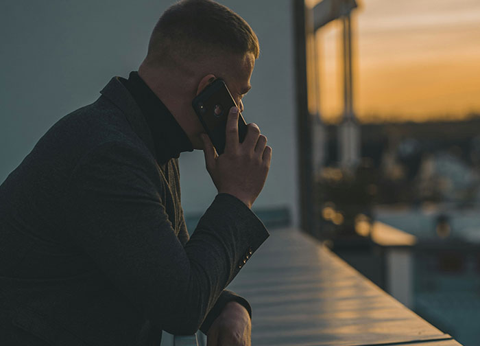 Man talking on phone outdoors at sunset, representing men getting brutally honest about what they never tell women. - 36