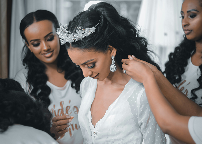 Bride getting ready with bridesmaids helping her, highlighting call off wedding and weird family tradition concepts.