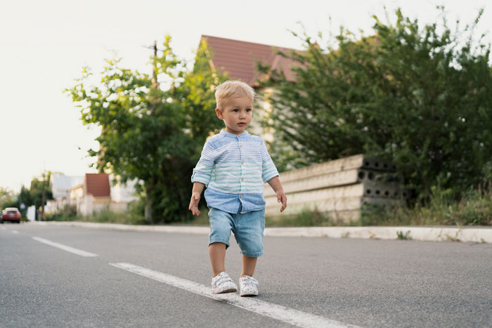 Toddler boy walking alone on a quiet street while neighbor has meltdown after calling cops on 2YO wandering the streets.
