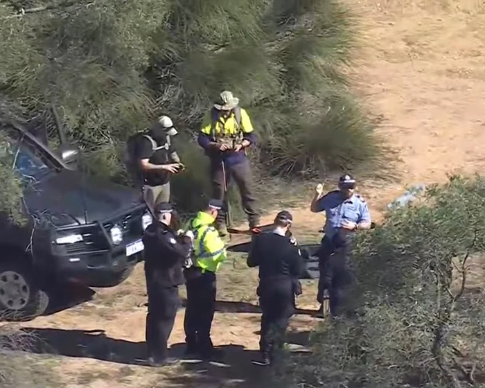 Rescue team with police officers at Australian Outback site where backpacker who went missing was found.