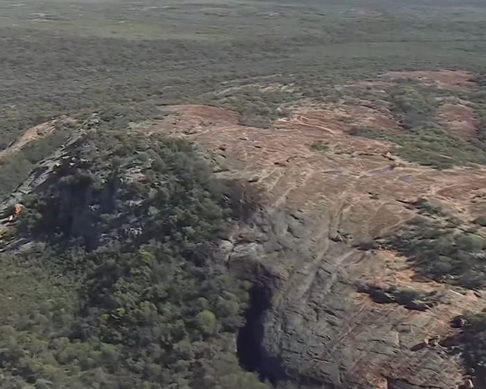 Aerial view of Australian outback terrain where backpacker who went missing after unexplained behaviour was found.