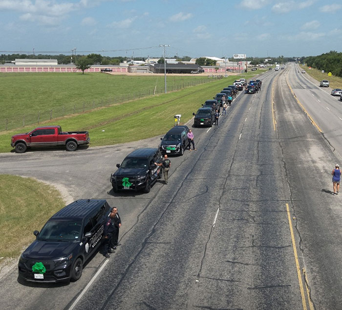 Funeral procession on highway after Camp Mystic tragedy with vehicles and people paying respects to 8-year-old's horse. - 3