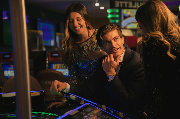 Casino workers in elegant attire sharing heartfelt and surprising stories while engaging with slot machines in a lively casino environment.